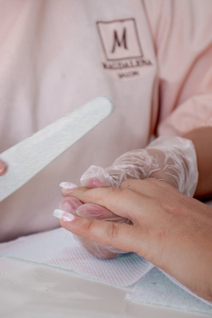 Close-up of a manicure procedure in a salon, showcasing detailed nail care techniques.